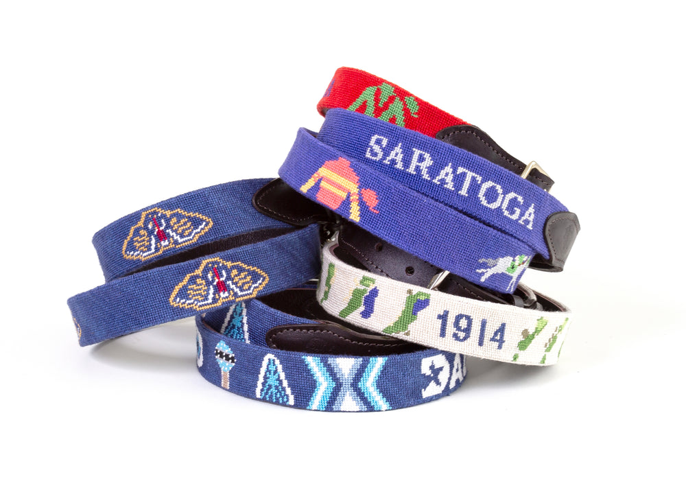 Colorful stitched designs on finished Good Threads needlepoint belts
